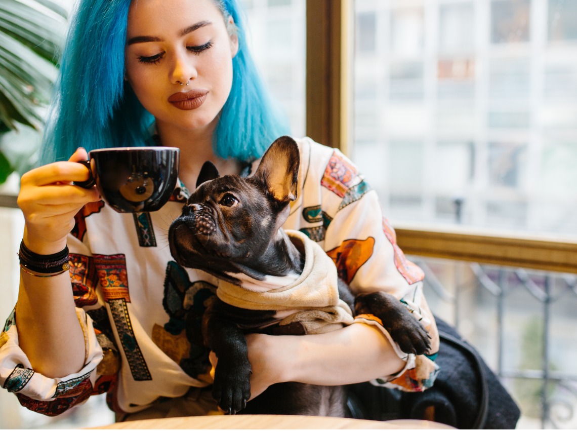 mujer con perro en cafeteria