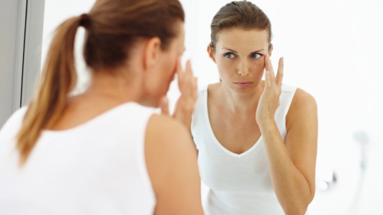 mujer tocándose el contorno de los ojos