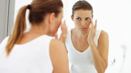 mujer tocándose el contorno de los ojos