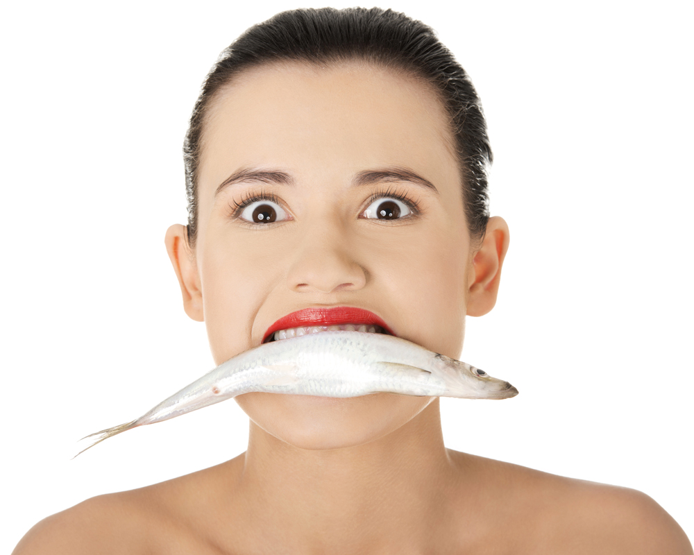 mujer con un pescado en la boca