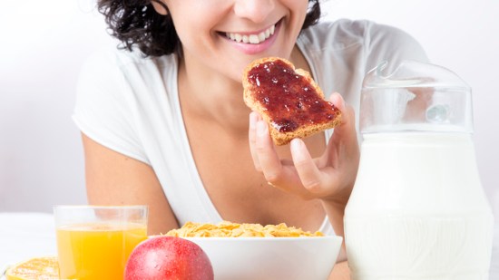 chica tomando un tostada de pan con mermelada