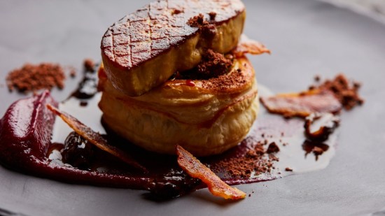 primer plano de hojaldre con foie sobre fondo negro