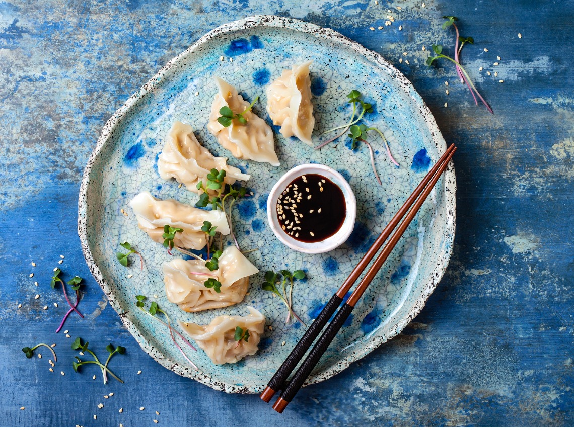dim sum sobre plato de color azul y palillos