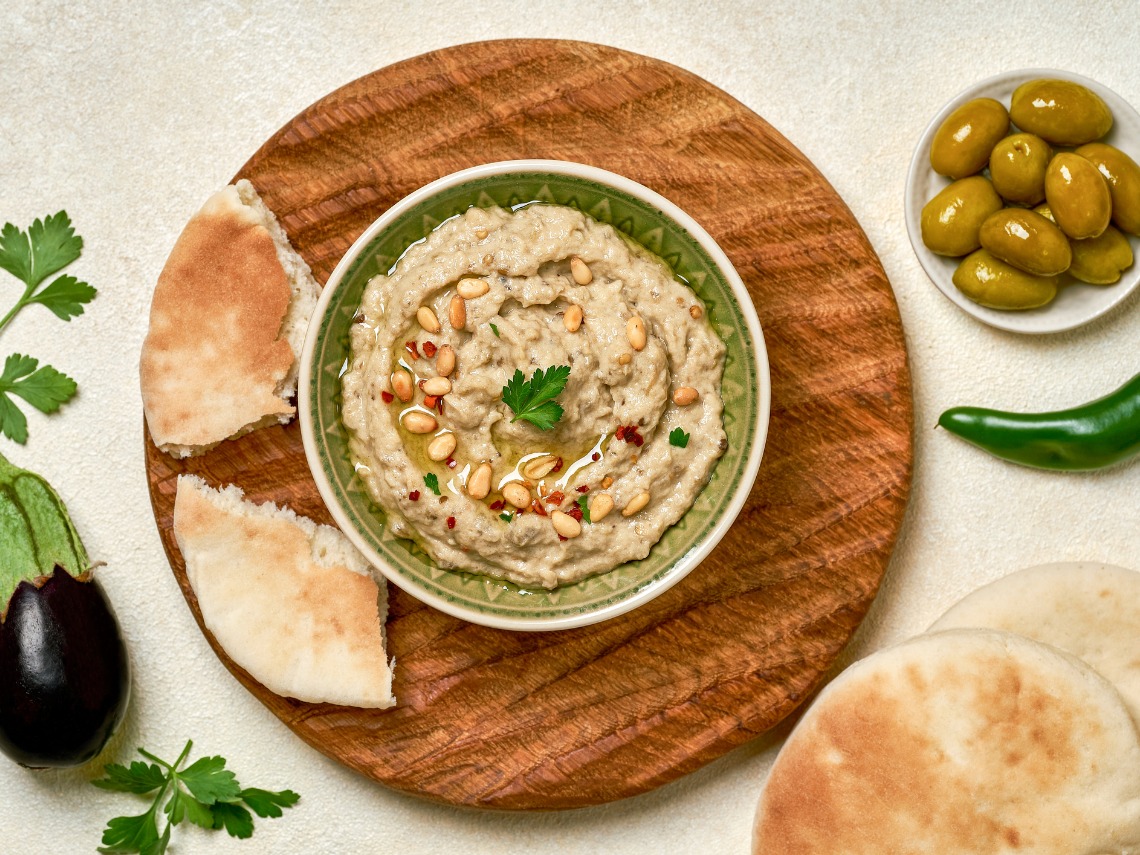 plano zenital baba ganoush en cuenco sobre mesa beige