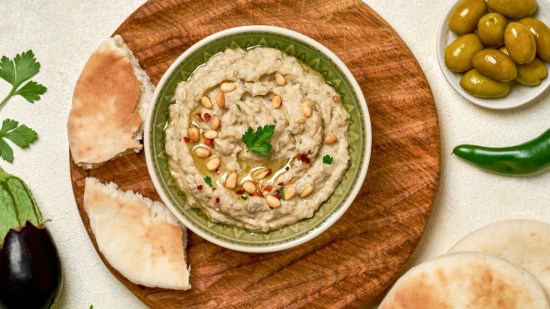 plano zenital baba ganoush en cuenco sobre mesa beige