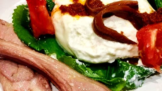 Cordero lechal con burrata al papillote de hoja de higuera y tomates