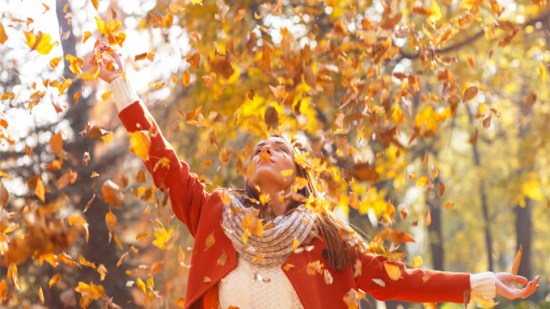 mujer bajo las hojas del otoño