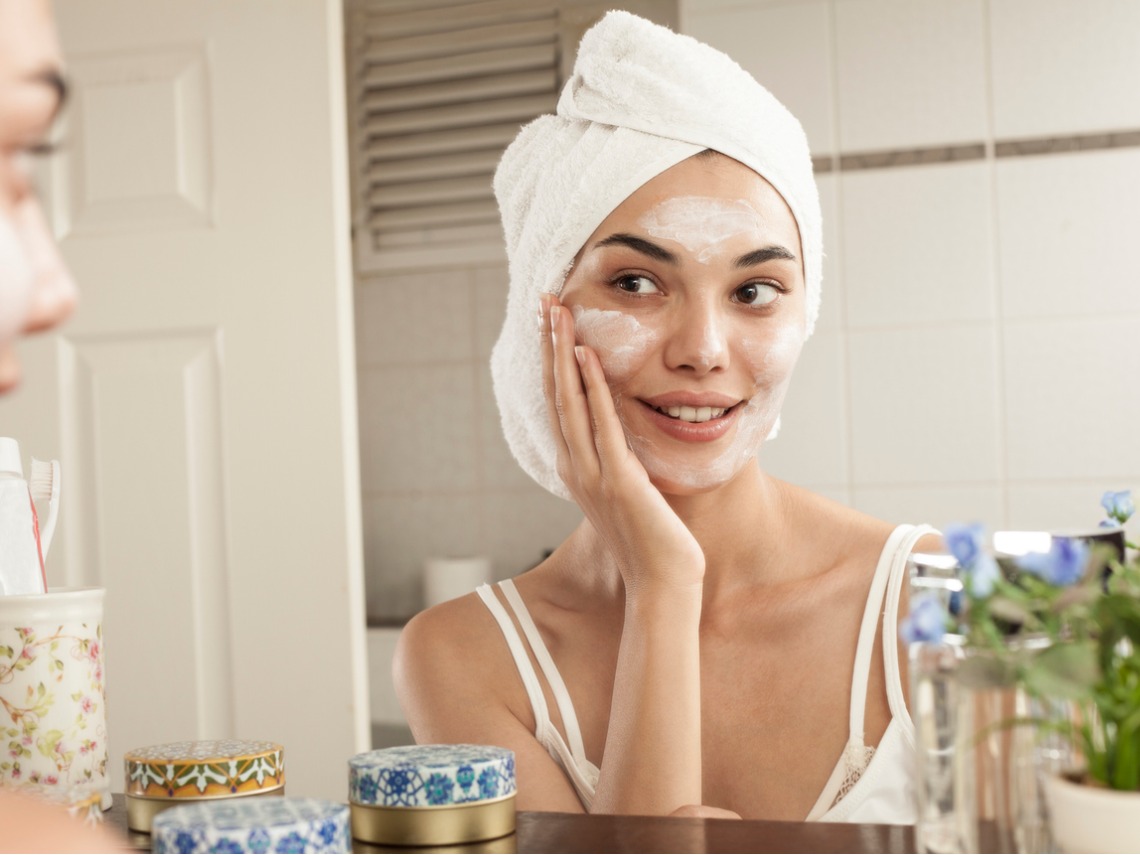 mujer aplicandose crema en la cara