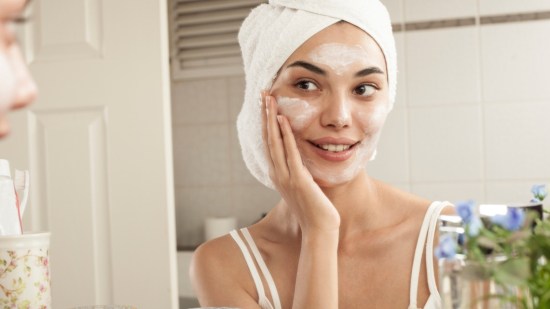 mujer aplicandose crema en la cara