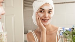 mujer aplicandose crema en la cara