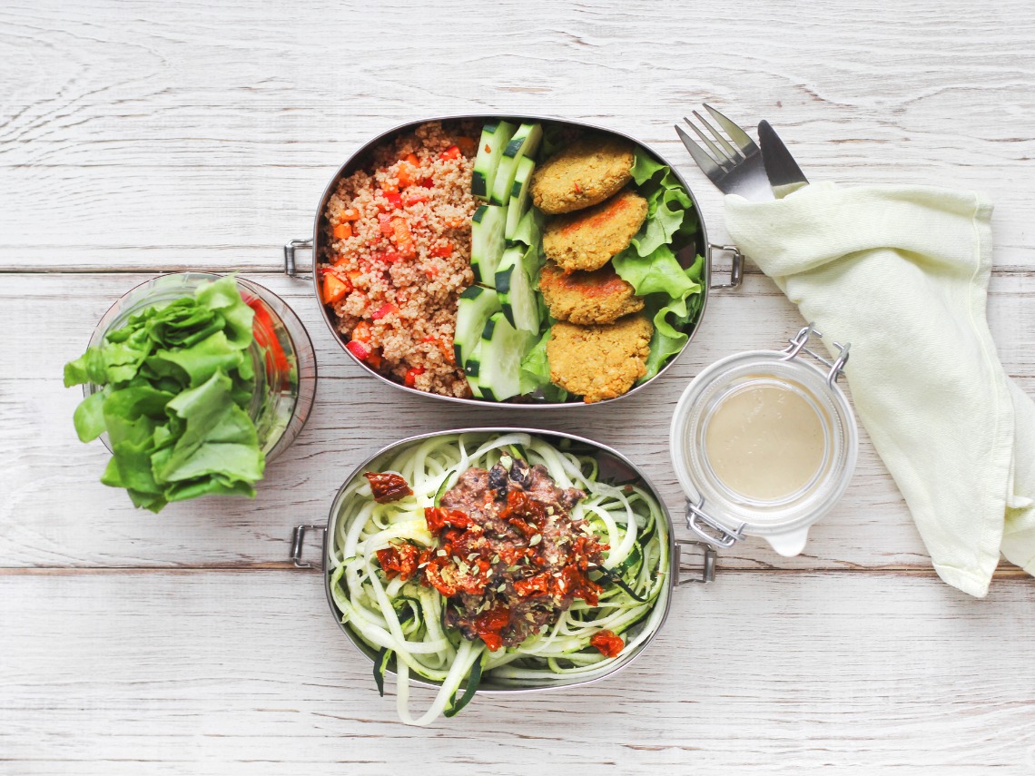 tuppers de ensalada sobre fondo blanco