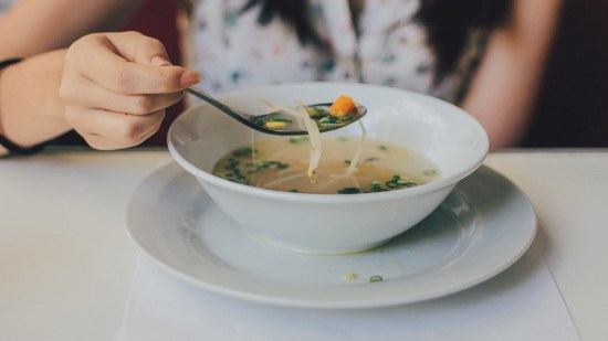 Mujer comiendo sopa