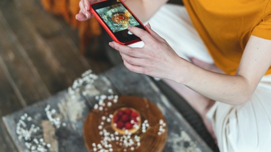 mujer haciendole foto con el movil a una tarta