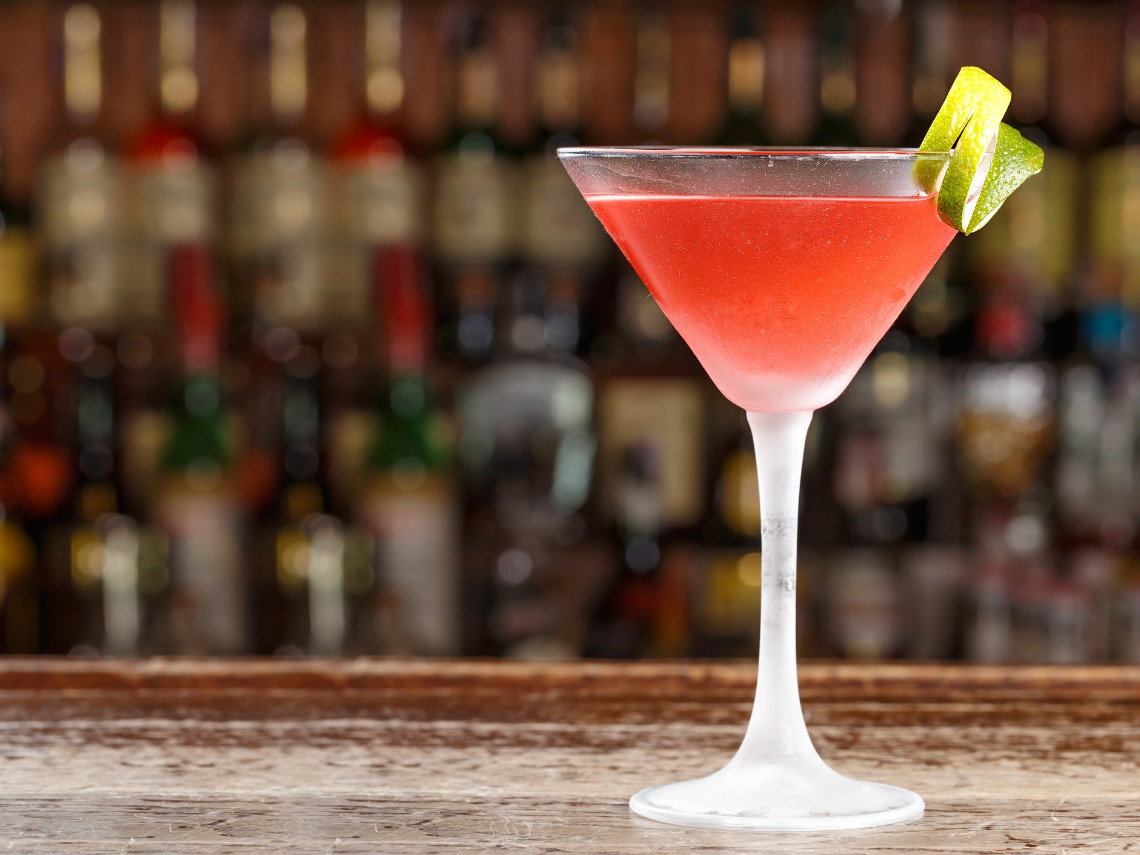 coctel cosmopolitan en copa de martini sobre barra de bar