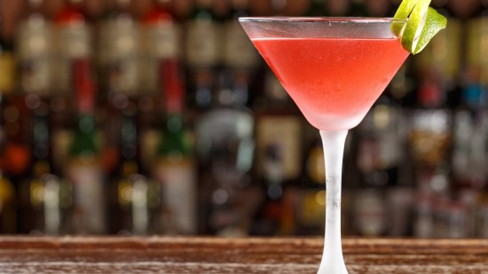 coctel cosmopolitan en copa de martini sobre barra de bar