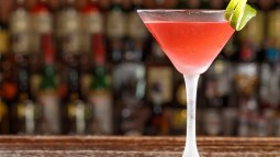 coctel cosmopolitan en copa de martini sobre barra de bar