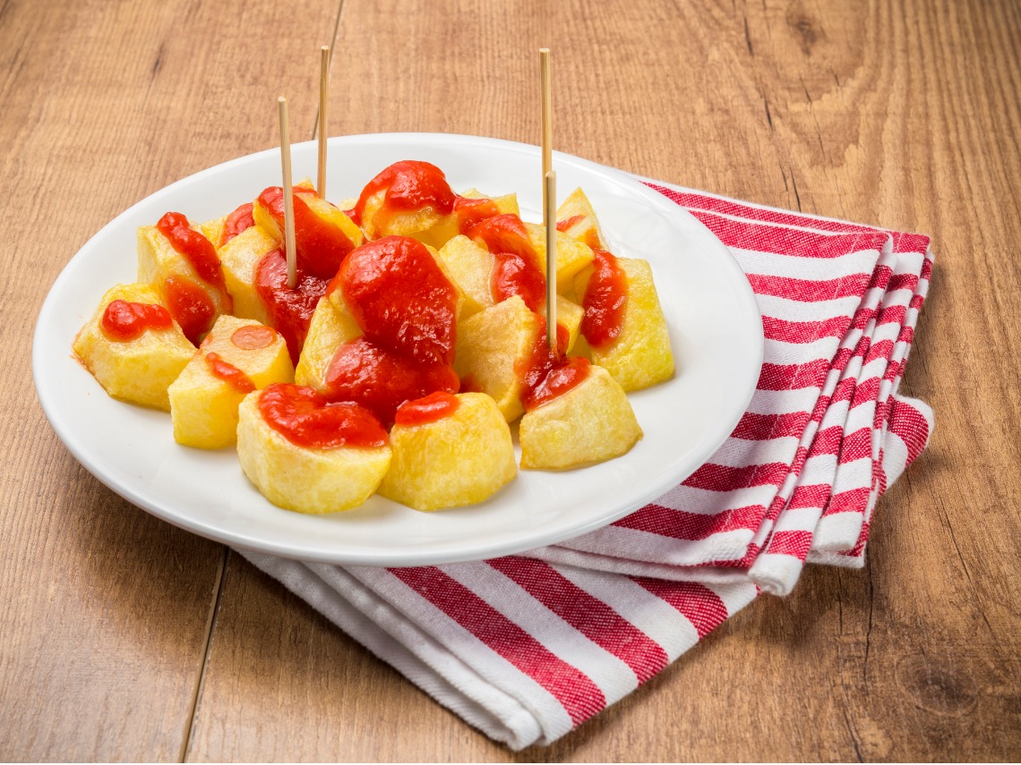 patatas bravas sobre mesa de madera