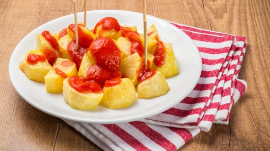 patatas bravas sobre mesa de madera