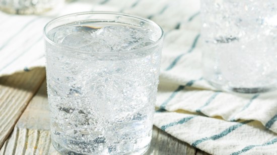 vaso de agua con gas sobre mesa plano zenital