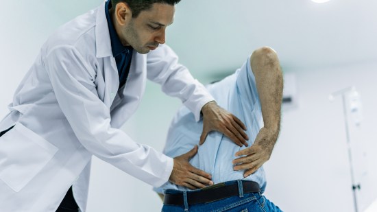 Médico examinando a paciente con dolor de espalda