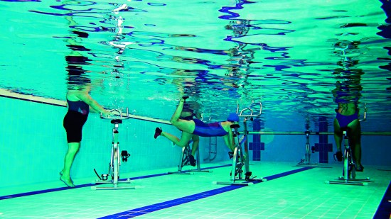 Antes de realizar ejercicios acuáticos, como el hidrobike, los expertos recomiendan caminar por la piscina.
