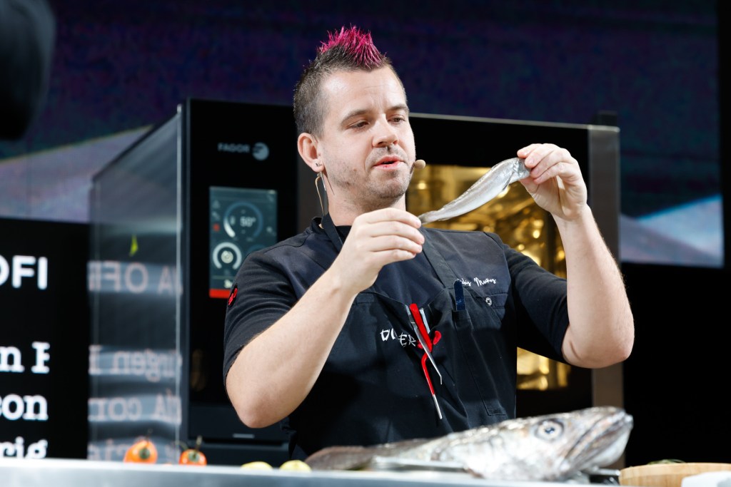 Dabiz Muñoz en acción, concentrado mientras prepara un plato en la cocina de DiverXO