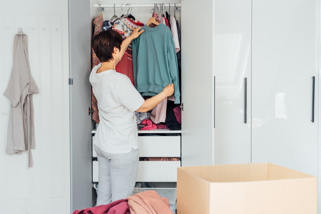 Orden en el armario: mujer preparando cajas para donar - Imagen: iStock