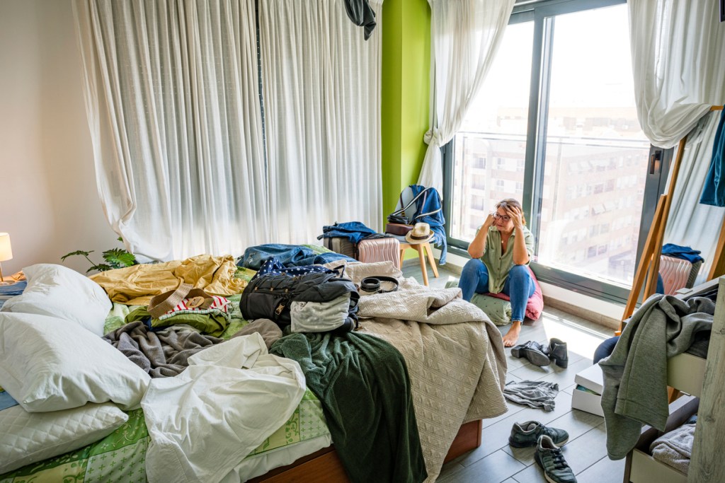Mujer estresada poniendo en orden su habitación - Imagen: iStock