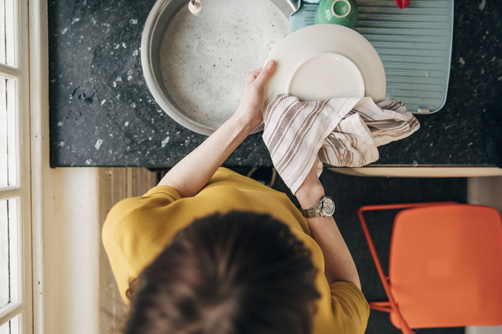 Mujer secando los platos con un trapo de cocina - Imagen: iStock